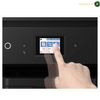 Epson EcoTank L14150 A3+ Large-Format Colour Printing | L14150. A close-up of a black printer control panel with a touchscreen display, showing a finger touching the screen. The image has a white border with an 'AMASOUQAE' watermark/logo in the top right corner.